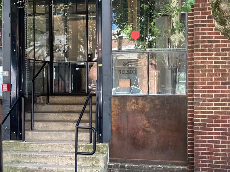 The entrance to Pegasus Studio from Nelson Street in Castleberry Hills. A short flight of stairs to the lobby door with Pegasus Studio logo on one of the windows to the studio.